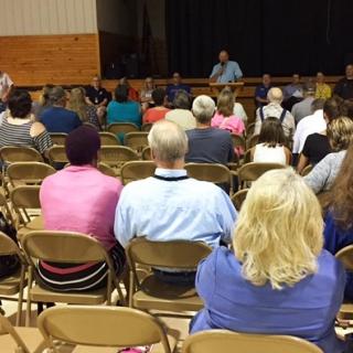 Presiding Commissioner Donald Black addresses a Carter County community meeting on flood recovery in Van Buren